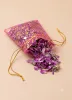 Sachet organza rose et or ouvert laissant apparaître des pétales de rose bio séchés